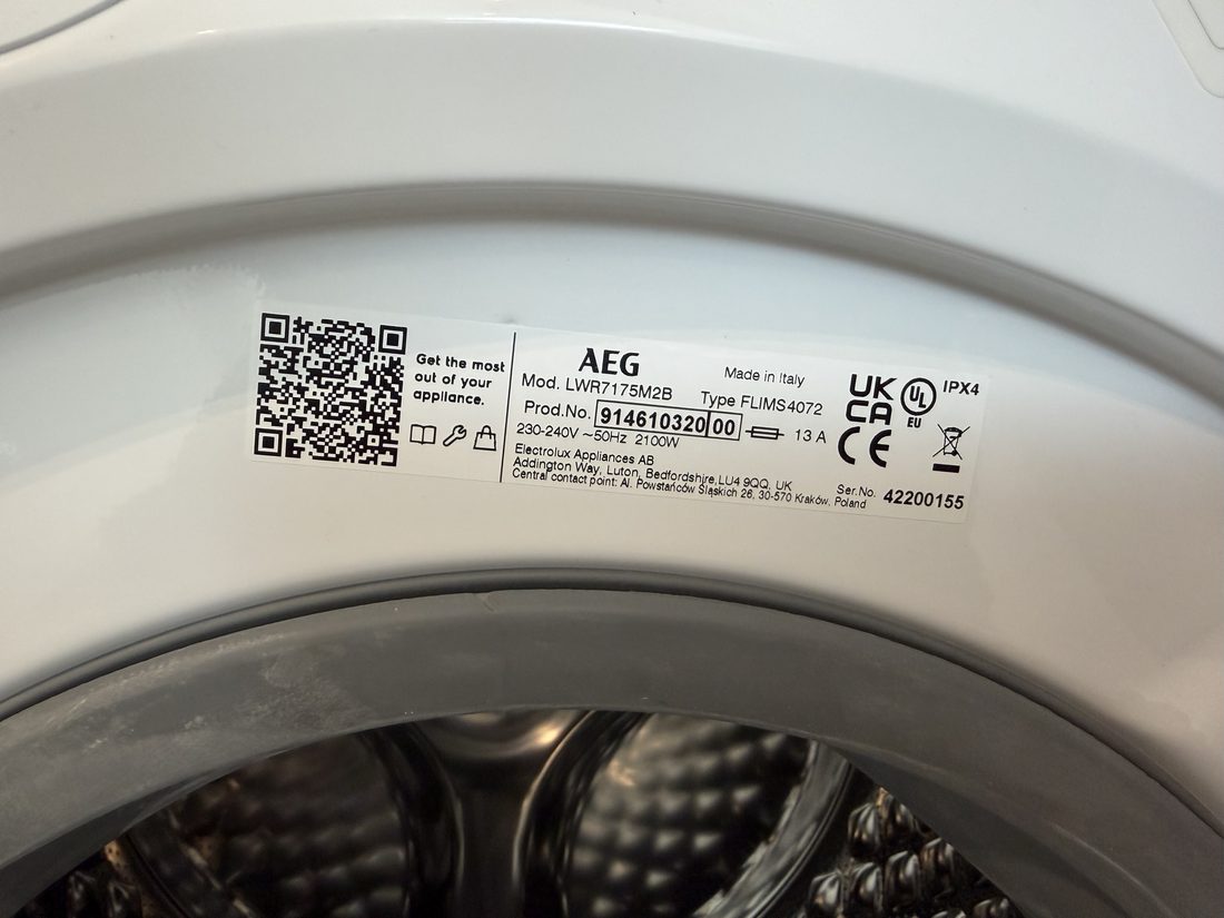 Close-up of the AEG washer-dryer specification plate in a Harvey W James listing